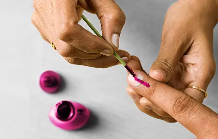 Pink ink applied on finger symbolizing breast cancer screening awareness inspired by Indian election ink tradition